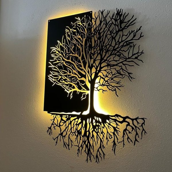 Luxury matte black laser-cut metal wall art depicting a detailed Tree of Life with intricate branches and exposed roots, illuminated by warm yellow LED backlighting, manufactured by Faisal Laser Works.